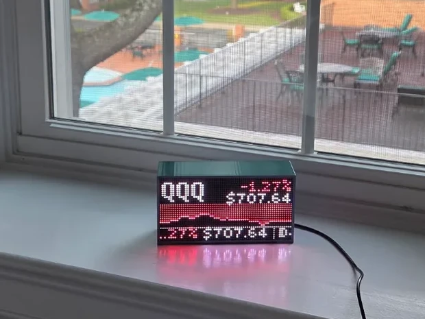 Beekon Light showing a grown-up scene: a stock ticker with a price chart in glowing pixels